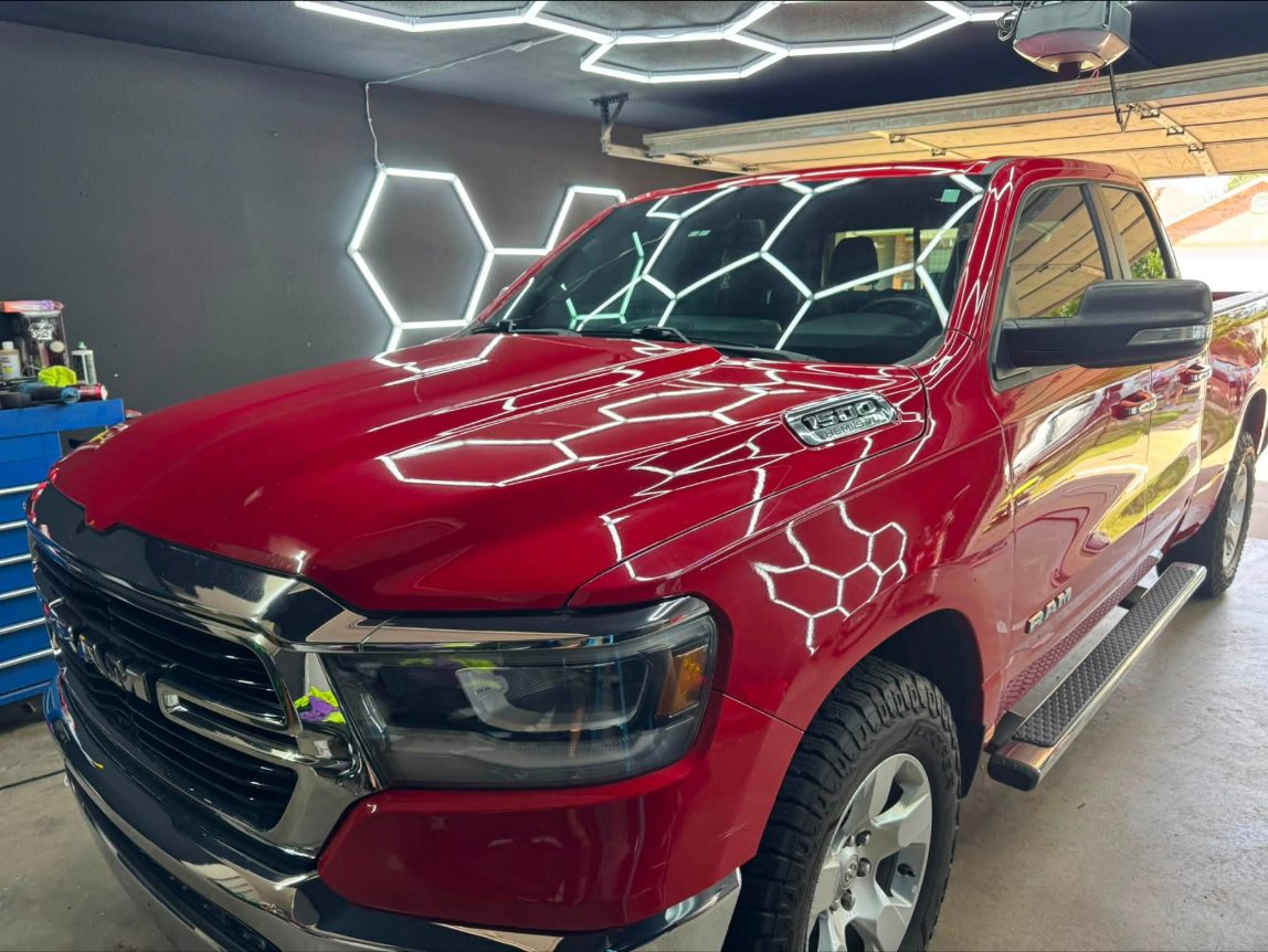 Red Ram 1500 in the shop, hood reflecting the hex lights